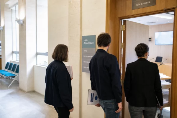Couloir lumineux d’un bâtiment public français avec salle d’audition et dossier sur les prix des carburants