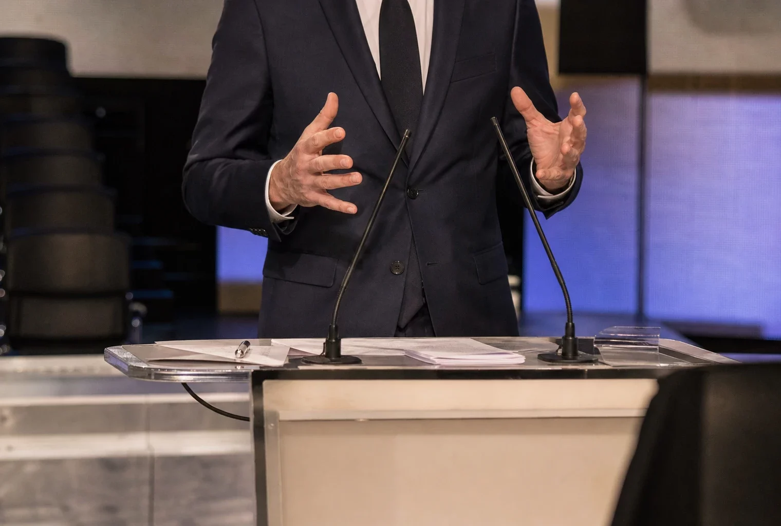 Plateau de débat avec pupitres et micros pour une primaire socialiste, en France.