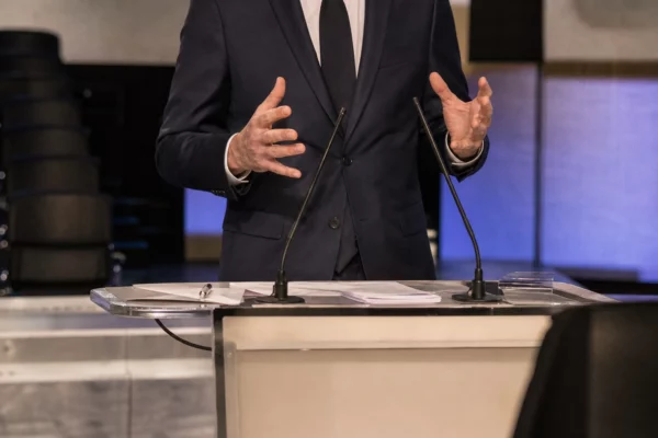 Plateau de débat avec pupitres et micros pour une primaire socialiste, en France.