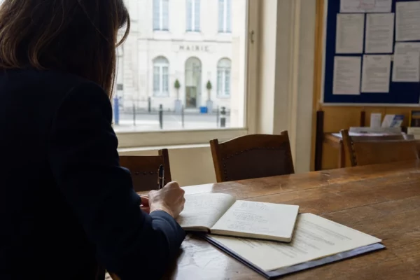 Collaborateur municipal prenant des notes dans une mairie française avant un débat européen