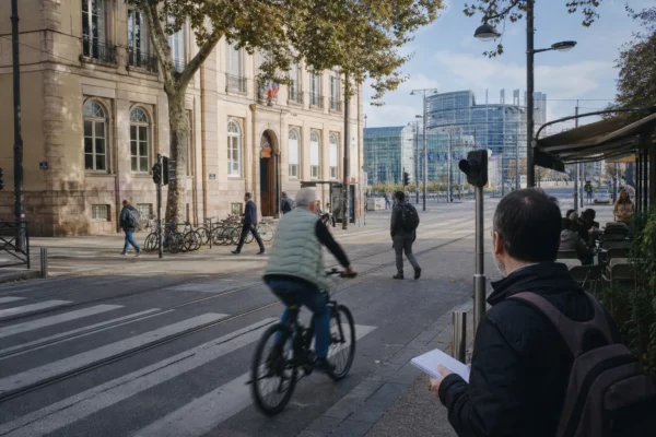Rue de Strasbourg près du quartier européen, avec habitants, cycliste et journaliste dans une scène de reportage claire