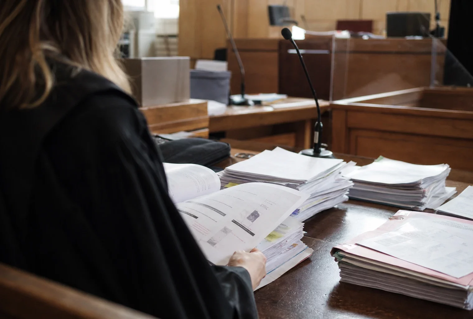 Dossiers, contrats et factures posés sur une table d’audience au tribunal, dans le cadre du procès Dati.