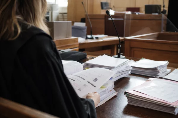 Dossiers, contrats et factures posés sur une table d’audience au tribunal, dans le cadre du procès Dati.