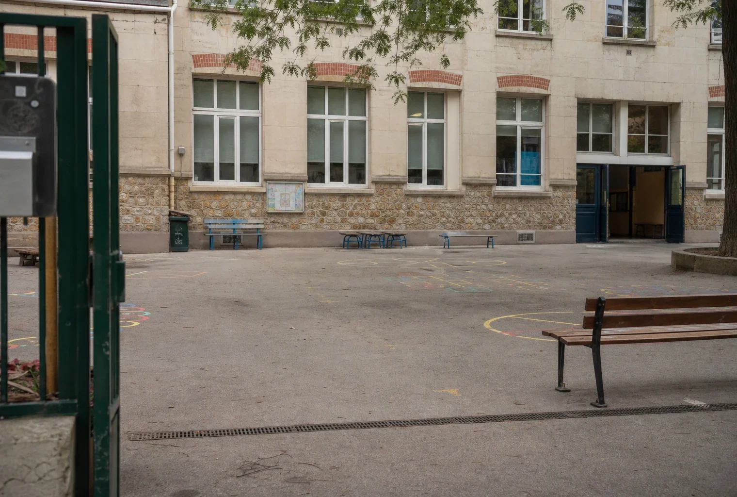 Devant une école parisienne, la cour et le portail rappellent le cadre des temps périscolaires des enfants.