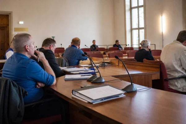 Salle de conseil local allemande après une élection, avec une chaise vide, des micros et des dossiers sur la table