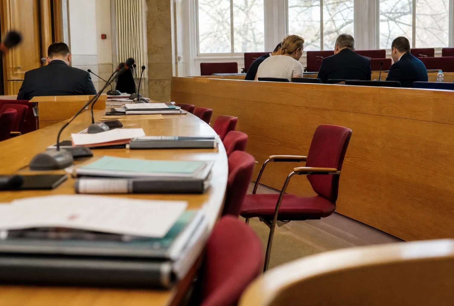 Salle de conseil régional allemande avec micros, dossiers flous et chaise vide avant les négociations politiques