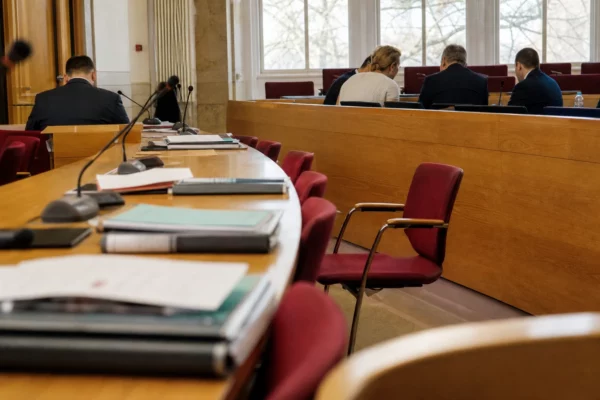 Salle de conseil régional allemande avec micros, dossiers flous et chaise vide avant les négociations politiques