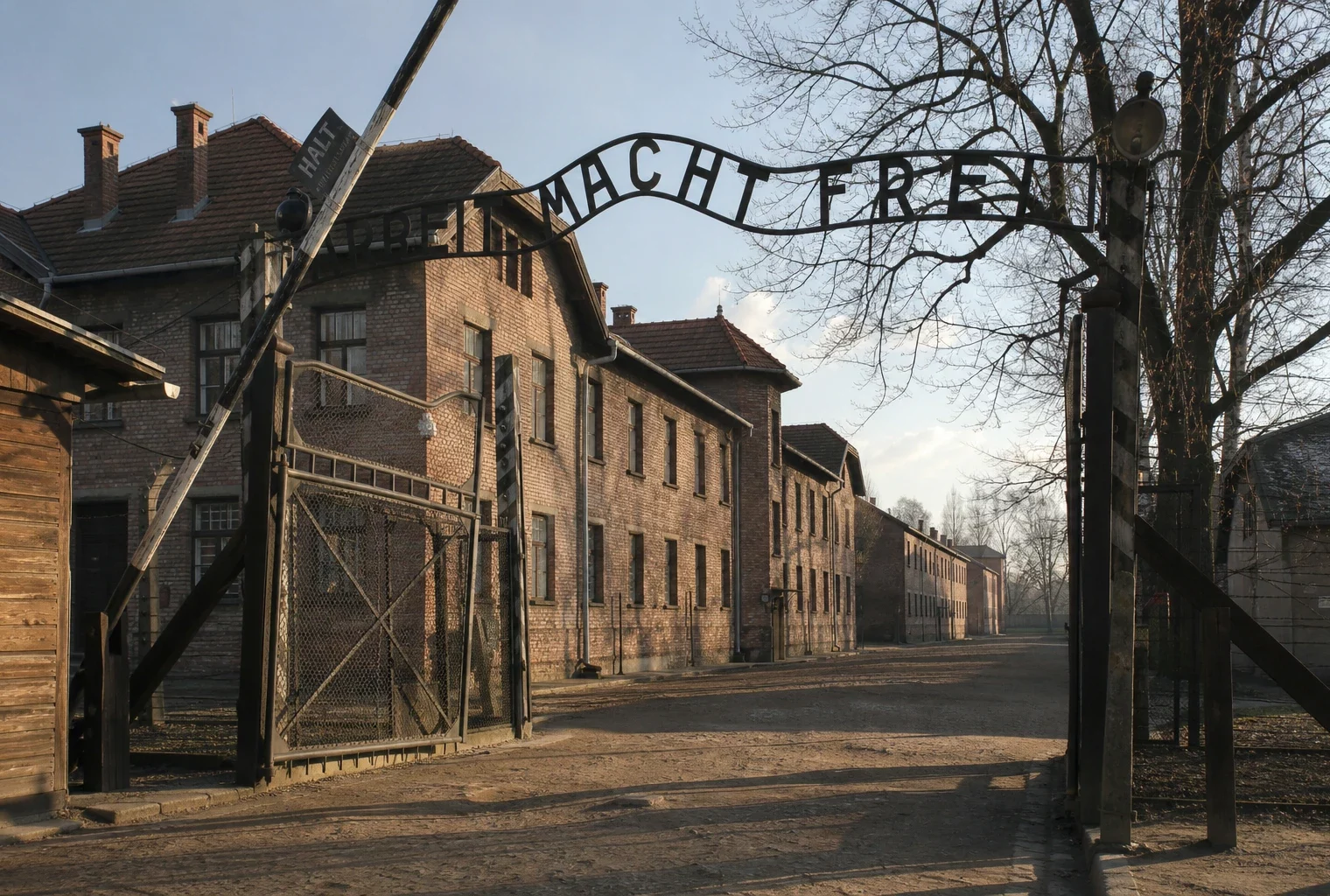 L’entrée d’Auschwitz I avec l’inscription historique au-dessus du portail, rappel matériel de la formule évoquée dans l’article.