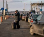 File de voitures et de voyageurs à un poste frontière, évoquant l’exode provoqué par une mobilisation.