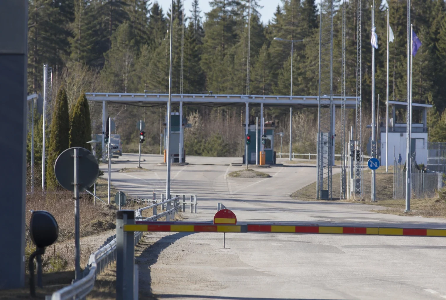 Un poste-frontière vide en Finlande, avec barrières et signalisation, au bord de la frontière avec la Russie.