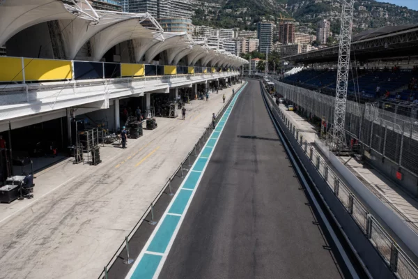 Vue haute du circuit de Monaco, avec rails de sécurité, stands, stands techniques et box sous le soleil de fin de matinée.