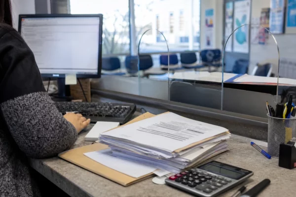 Guichet d’aides au logement avec dossiers et ordinateur, dans une antenne de la CAF en France