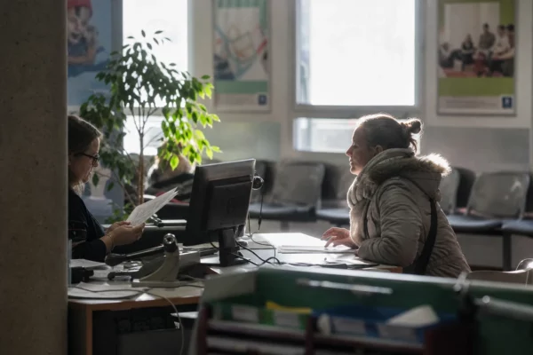 Guichet d’accueil d’une caisse d’allocations, avec dossiers et sièges d’attente dans un service public.