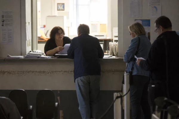 Un guichet de service public avec des dossiers, des chaises d’attente et un comptoir administratif.