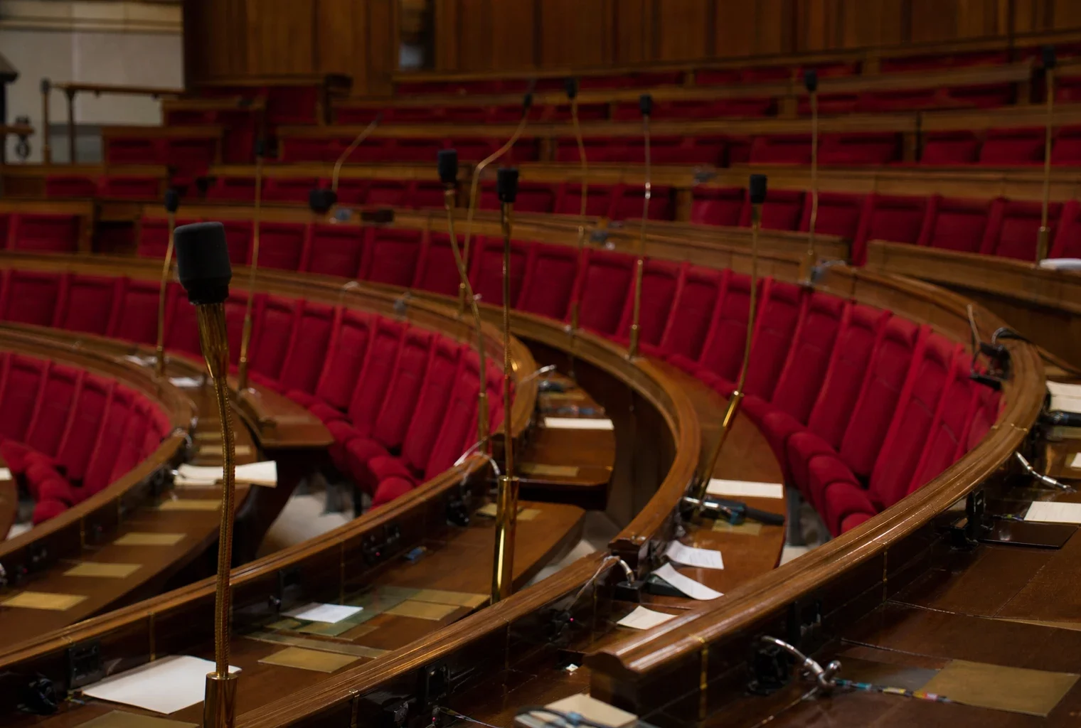 L’hémicycle de l’Assemblée nationale vide, avec ses rangées de sièges et ses pupitres.