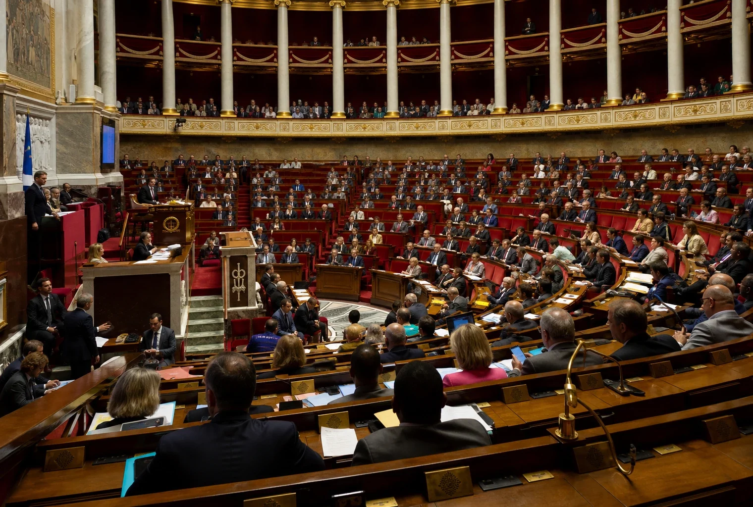 L’hémicycle de l’Assemblée nationale avec ses rangées de bancs et de pupitres, vide de députés.
