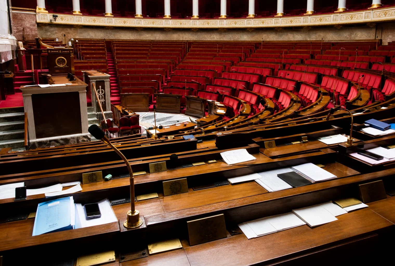 L’hémicycle de l’Assemblée nationale, avec ses pupitres et micros, en attente d’un vote.