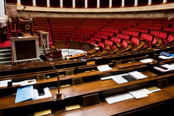 L’hémicycle de l’Assemblée nationale, avec ses pupitres et micros, en attente d’un vote.
