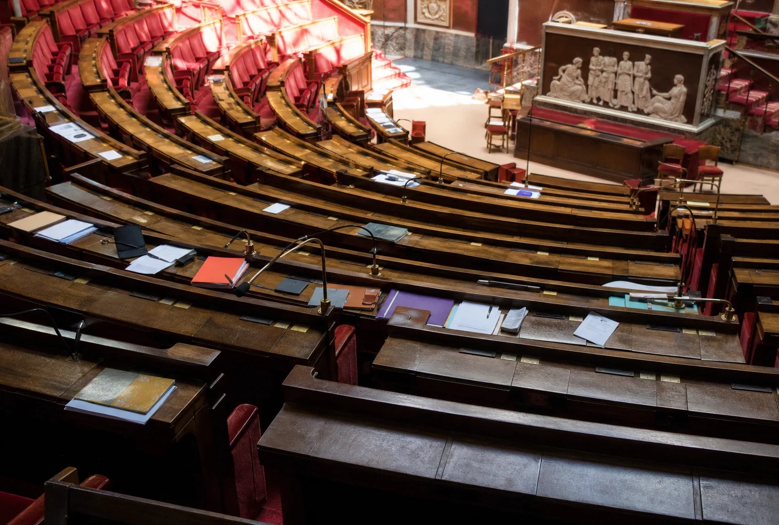 L’hémicycle de l’Assemblée nationale vide, avec ses pupitres et micros, au cœur du débat sur les contre-pouvoirs.