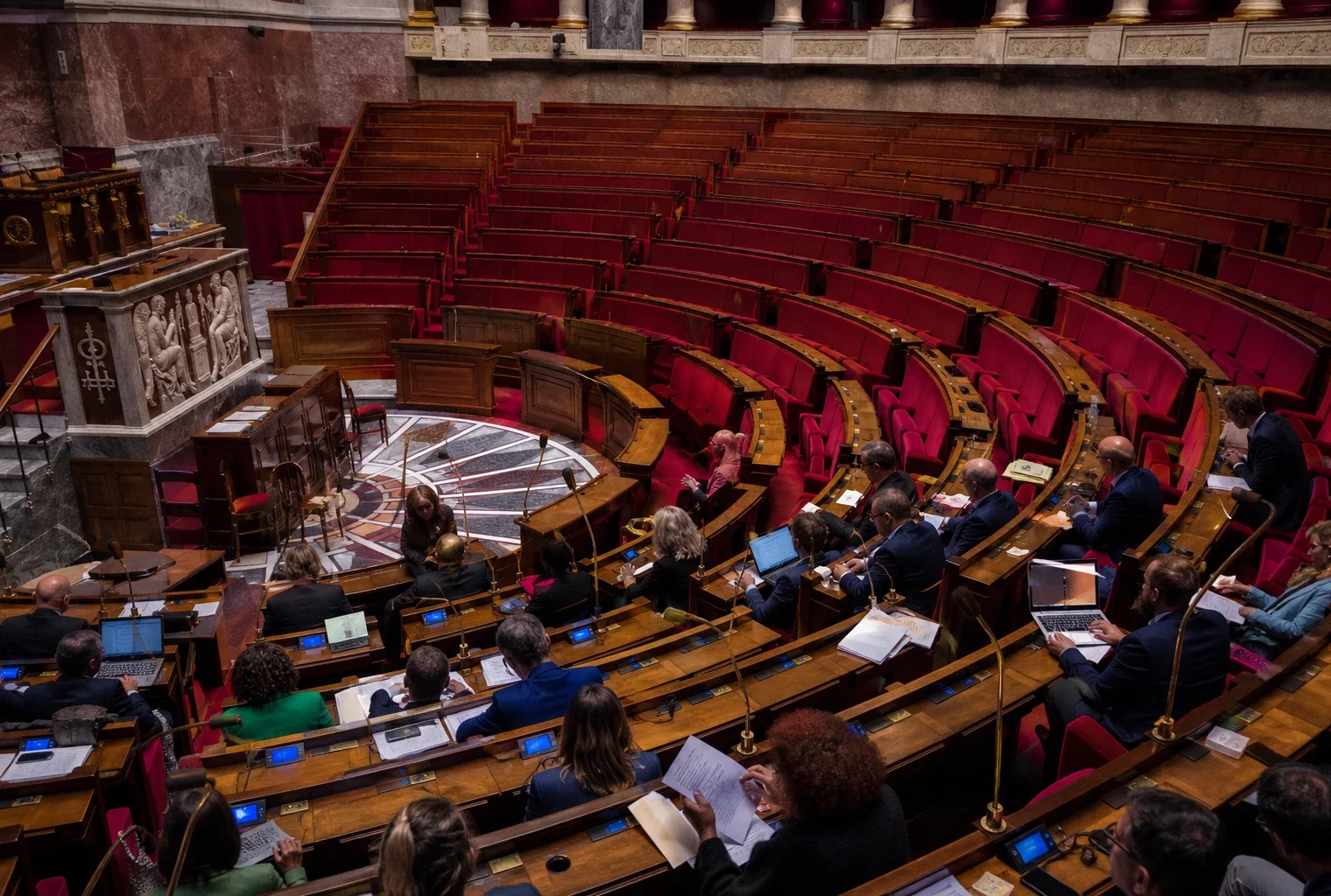 Hémicycle de l’Assemblée nationale vide avec ses pupitres et sièges de vote, pour illustrer les motions de censure.