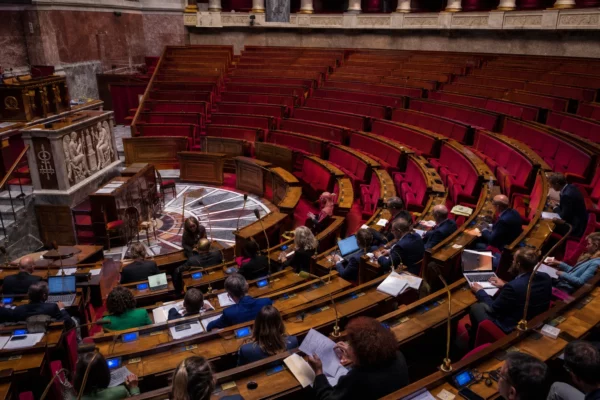 Hémicycle de l’Assemblée nationale vide avec ses pupitres et sièges de vote, pour illustrer les motions de censure.