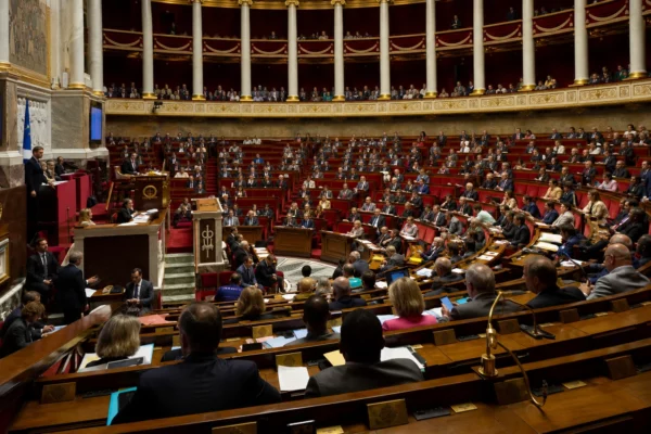 L’hémicycle de l’Assemblée nationale avec ses rangées de bancs et de pupitres, vide de députés.