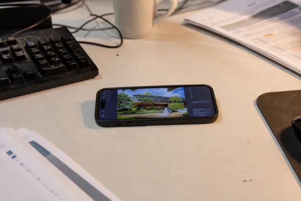 Un smartphone affiche une image générée par IA, posé sur un bureau avec des papiers et un clavier.