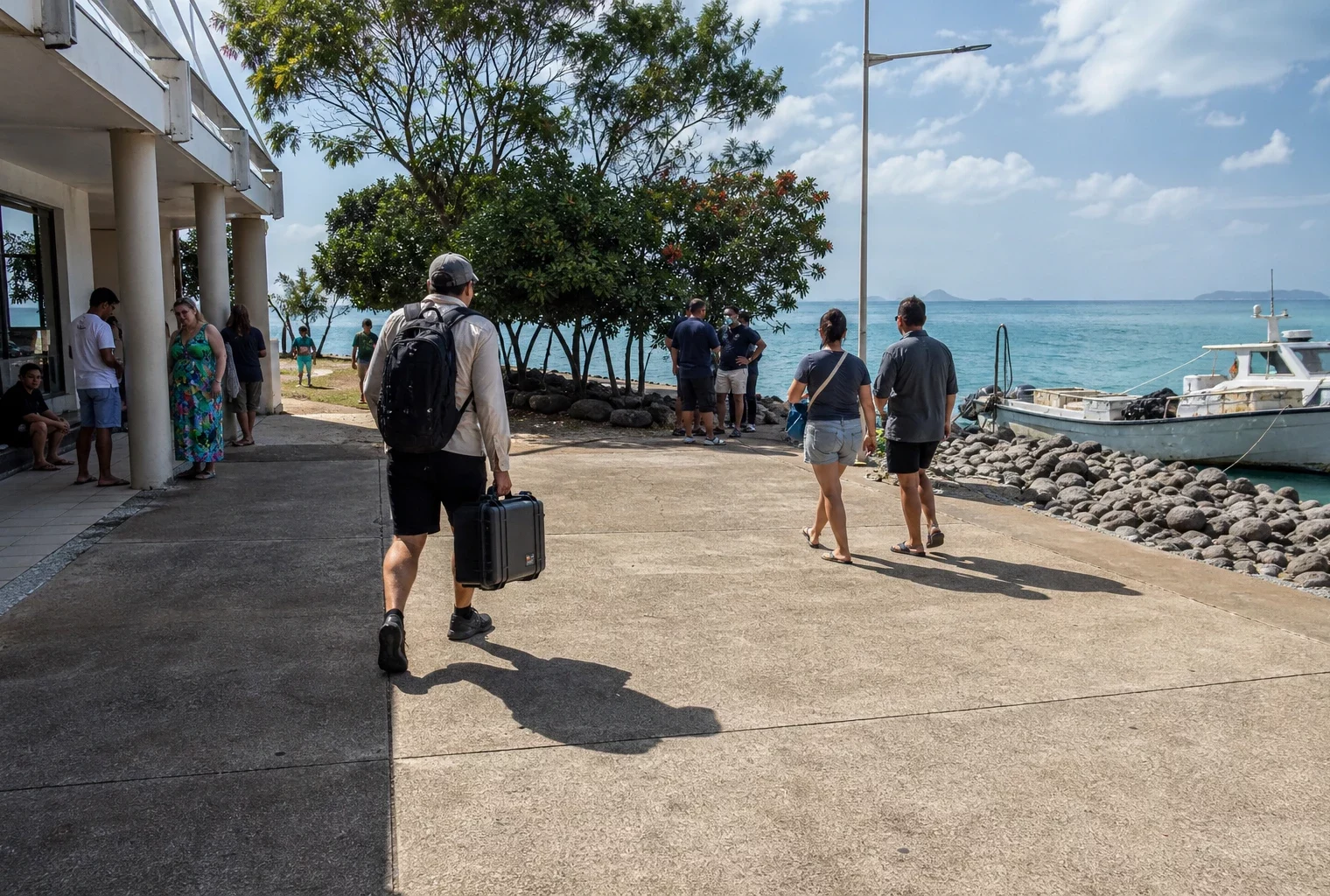 Place côtière de Nouvelle-Calédonie face au Pacifique, avec habitants anonymes et embarcation de pêche au port
