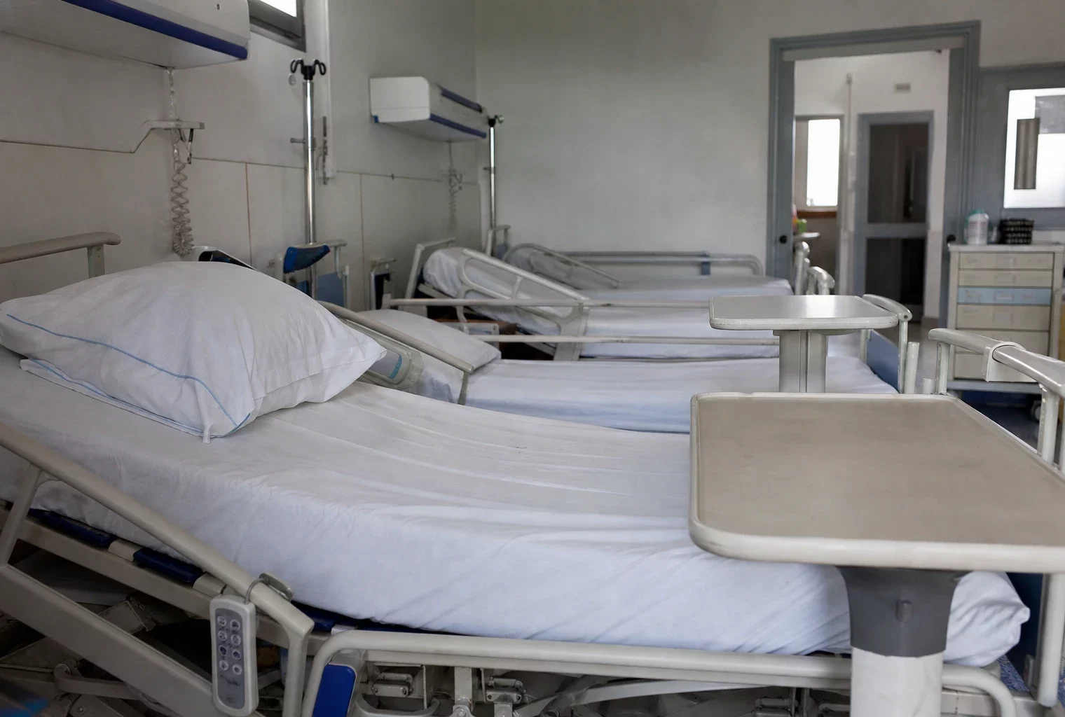 Des lits d’hôpital vides dans une chambre de soins, symbole des moyens hospitaliers en tension.