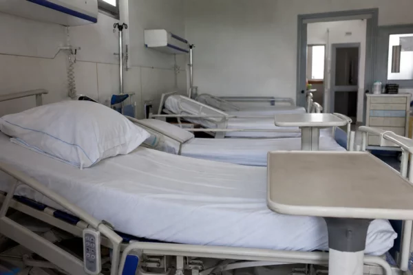 Des lits d’hôpital vides dans une chambre de soins, symbole des moyens hospitaliers en tension.