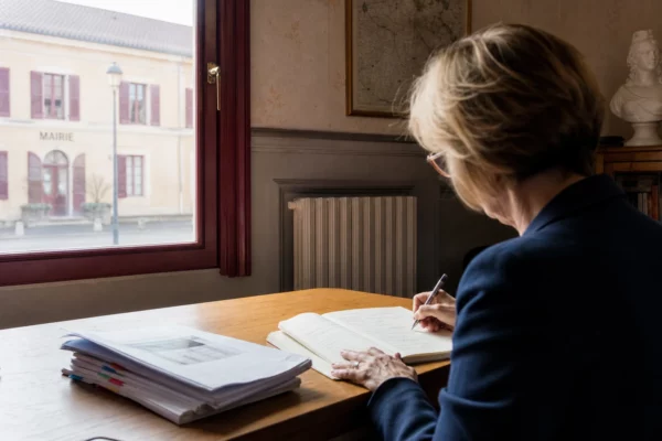 Élu local anonyme prenant des notes sur une loi de protection dans un bureau de mairie française
