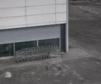 Devanture de magasin en Russie avec chariots alignés, rideau de sécurité abaissé et parking vide sous lumière diffuse.