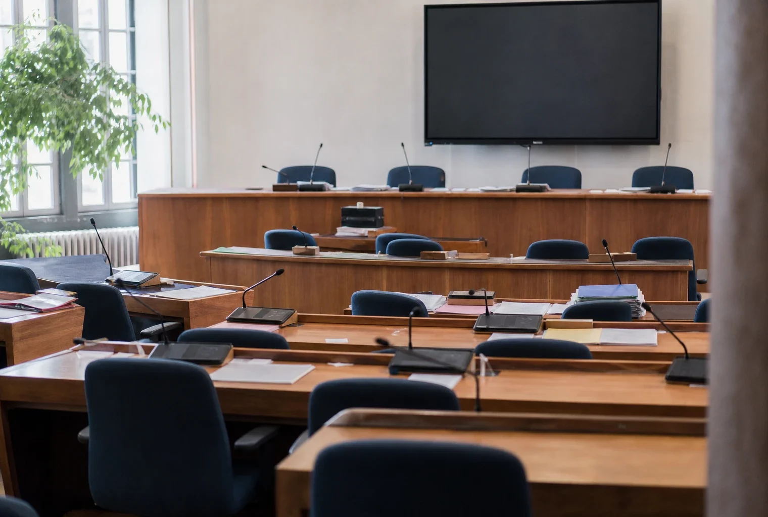 Salle du conseil municipal vide avec pupitres et micros, pour illustrer la tension autour de la mairie de Concarneau.
