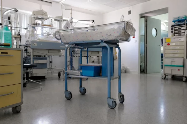 Une maternité avec un berceau de nouveau-né et du matériel de soins, en lien avec la naissance de Léon à Lens.