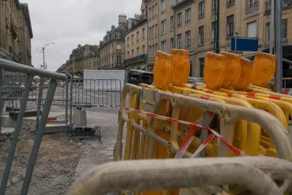 Barrières de sécurité et circulation bloquée à Metz, le long du parcours papal, sous un ciel gris uniforme.