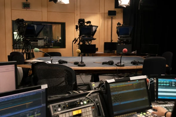 Plateau d’émission politique avec micros, caméras et table d’interview avant un débat télévisé.