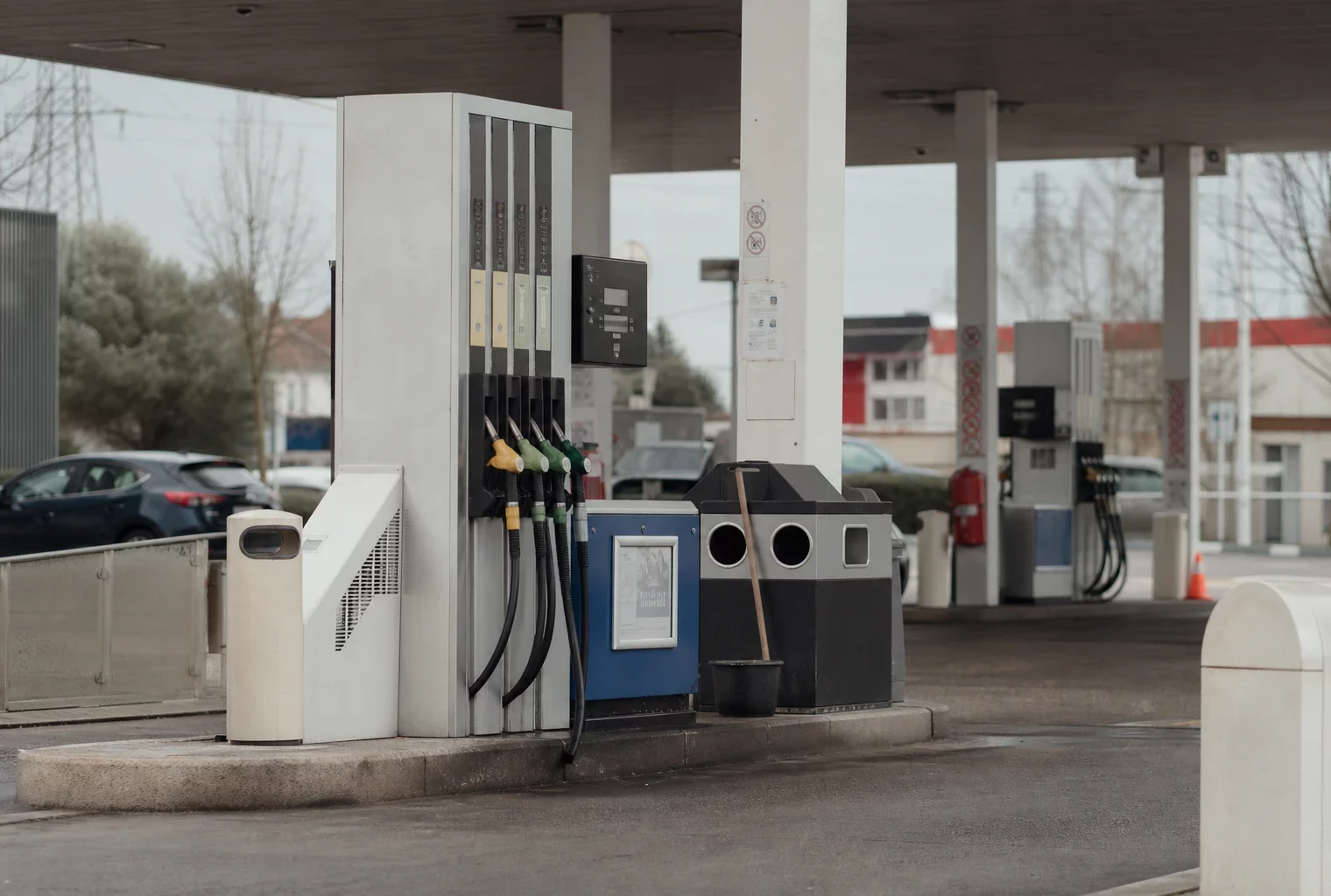 Pompe à carburant d’une station-service en bord de route, avec flexibles et afficheur de prix.