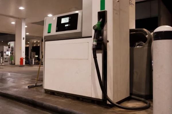 Pompe à carburant dans une station-service, avec flexible et affichage du prix.