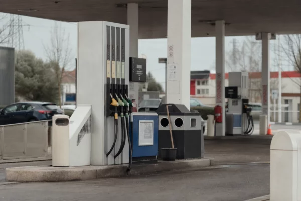 Pompe à carburant d’une station-service en bord de route, avec flexibles et afficheur de prix.