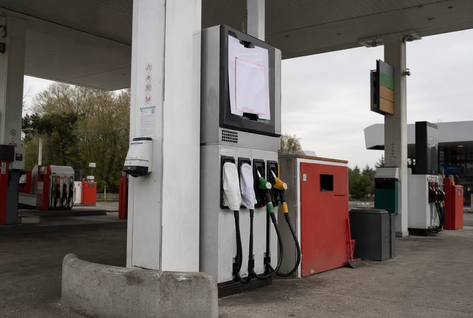 Pompe de station-service avec affichage de rupture de carburant et autres bornes en arrière-plan.