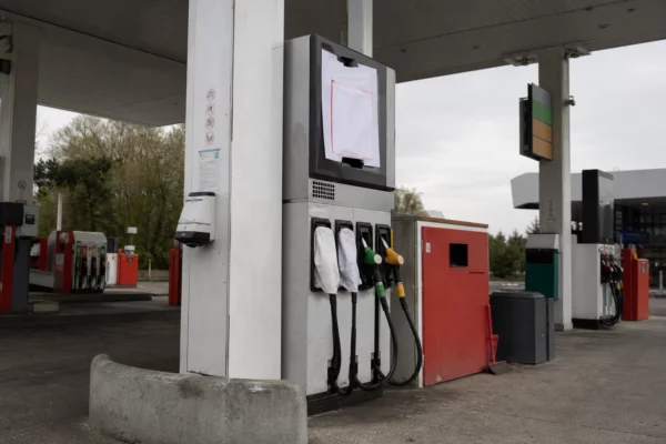 Pompe de station-service avec affichage de rupture de carburant et autres bornes en arrière-plan.
