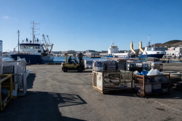 Quai d’approvisionnement à Saint-Pierre-et-Miquelon avec marchandises et engins de manutention, au cœur de la vie quotidienne.