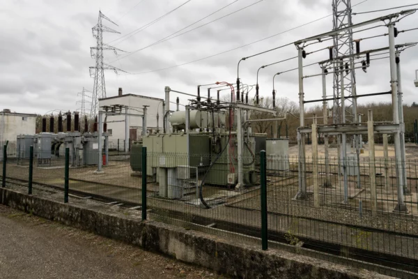 Un poste électrique de distribution avec transformateurs et grillage, symbole des infrastructures à protéger.