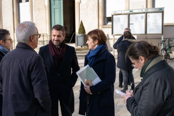 Citoyens anonymes échangeant devant une mairie française sur les enjeux européens et la sécurité du continent