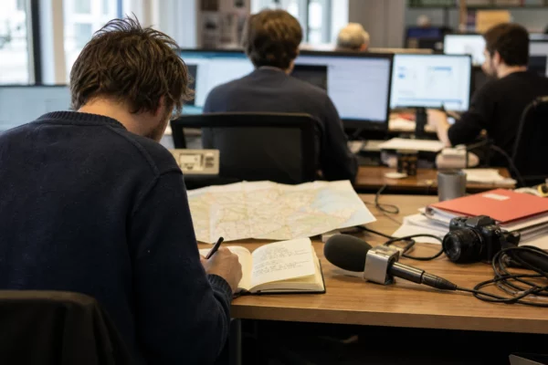 Journaliste préparant un sujet sur la primaire de la droite et du centre dans une rédaction française lumineuse