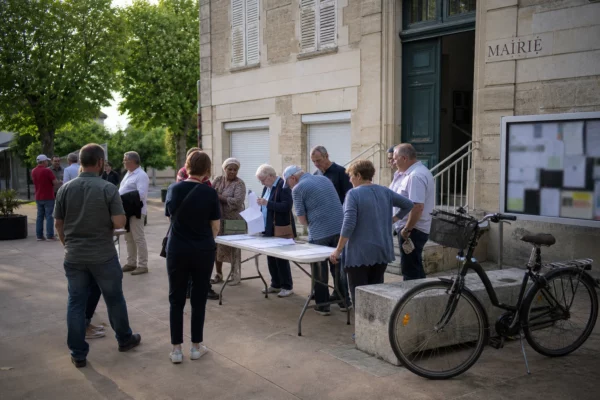 Réunion citoyenne dans une ville française autour d’une primaire de gauche, avec élus locaux et habitants anonymes