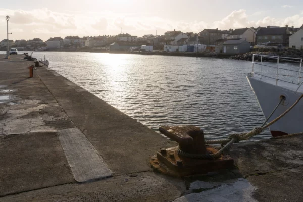 Un quai de port à Saint-Pierre-et-Miquelon, avec les équipements maritimes du front de mer et des bâtiments bas en arrière-plan.