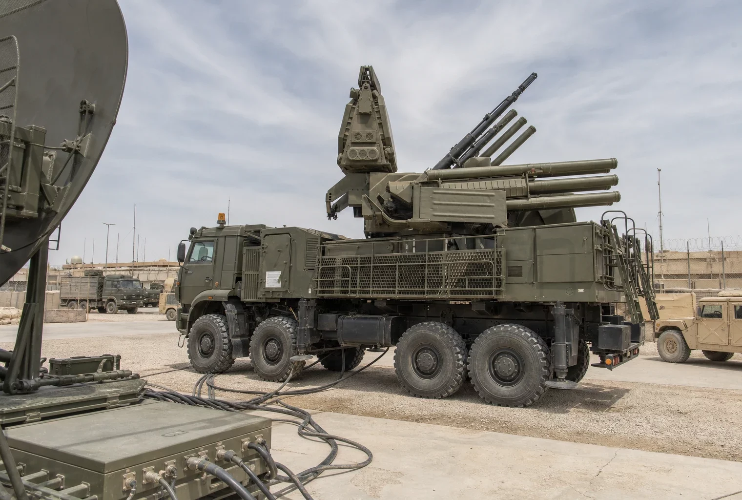 Radar et système de défense militaires sur une base saoudienne, avec véhicules et structures techniques en arrière-plan.