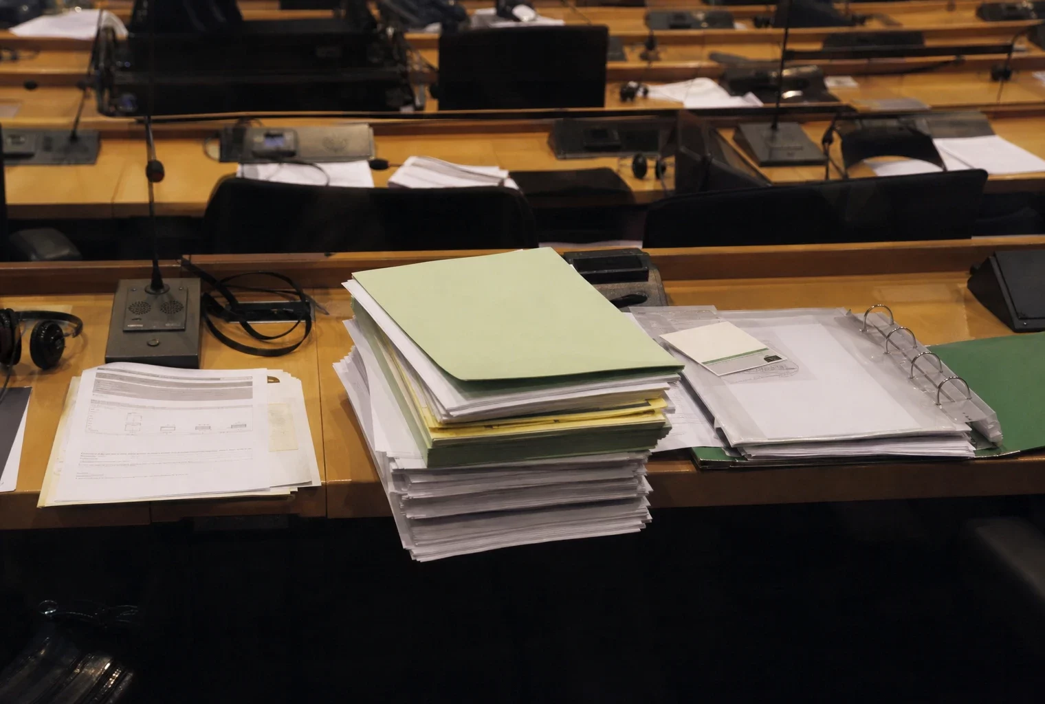 Des dossiers de travail posés sur une table dans une salle de commission du Parlement européen à Bruxelles.