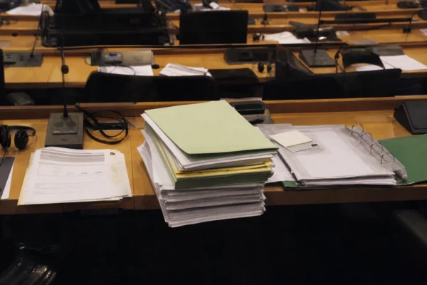 Des dossiers de travail posés sur une table dans une salle de commission du Parlement européen à Bruxelles.